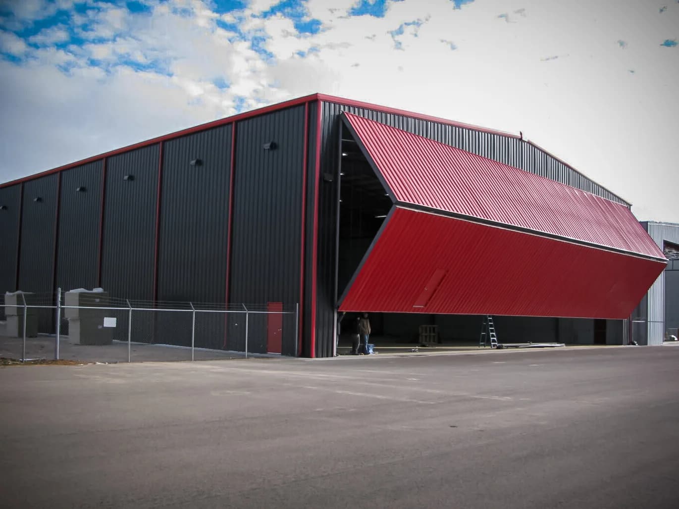 Black and red steel aviation hangar with bifold door