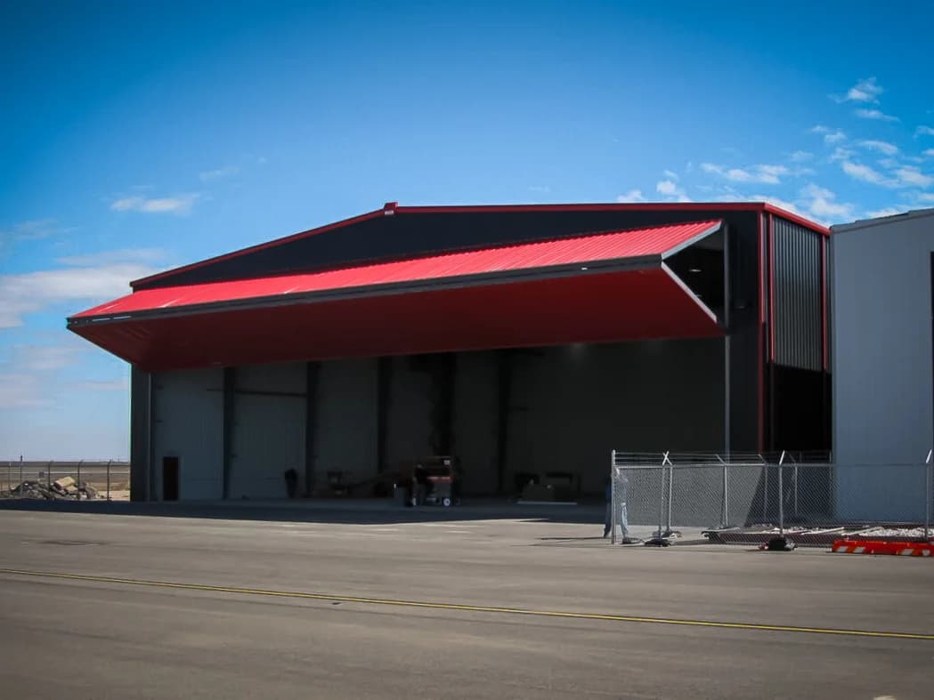 Steel aviation hangar side angle showing bifold door mechanism