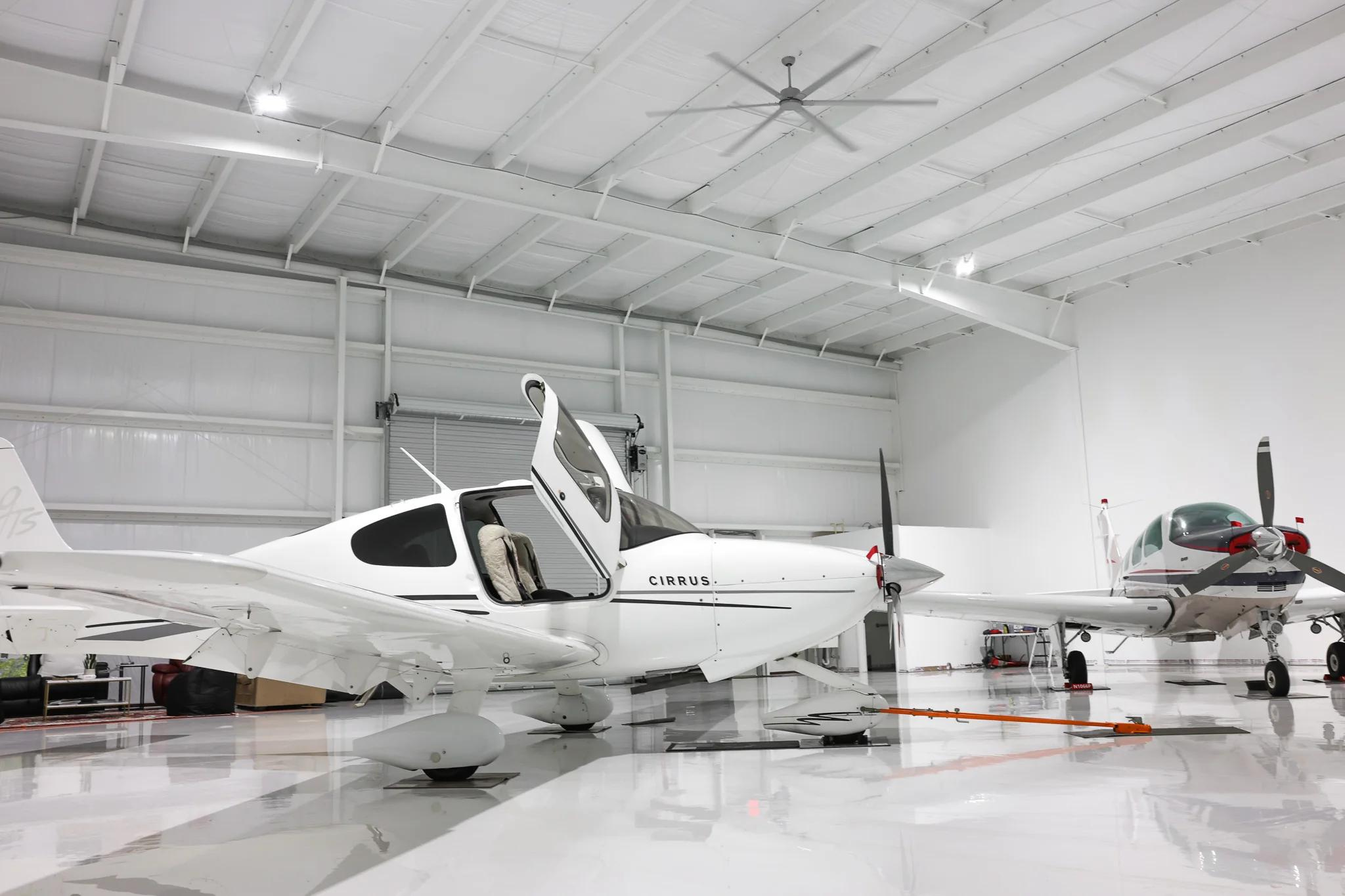 Cirrus aircraft with canopy open on polished epoxy floor
