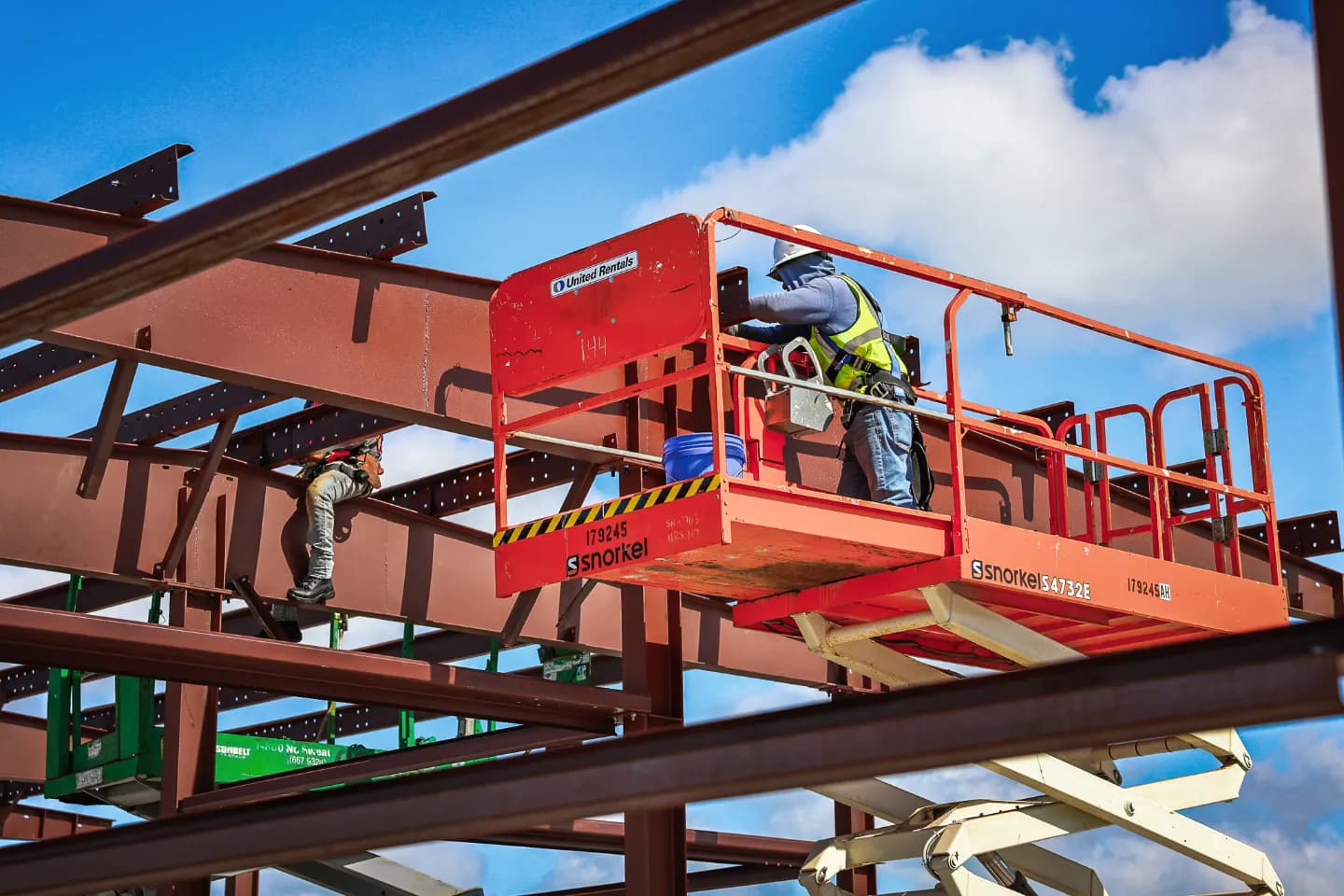 Red iron I-beam steel framing during barndominium construction