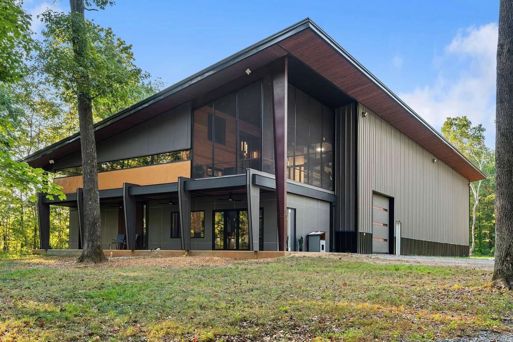 Completed red steel barndominium with white trim and metal roof